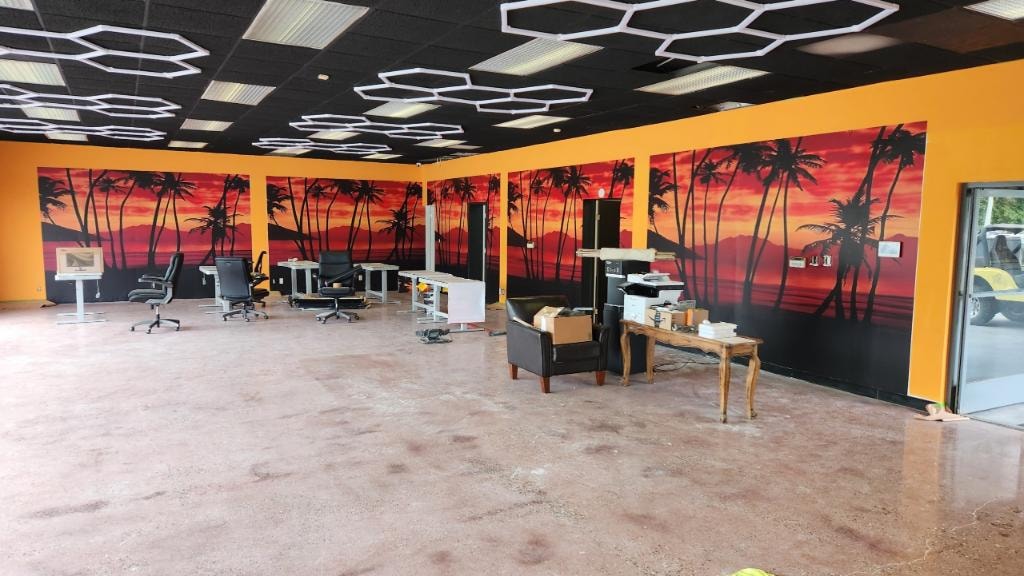 Completed tropical sunset mural covering all walls of commercial office space