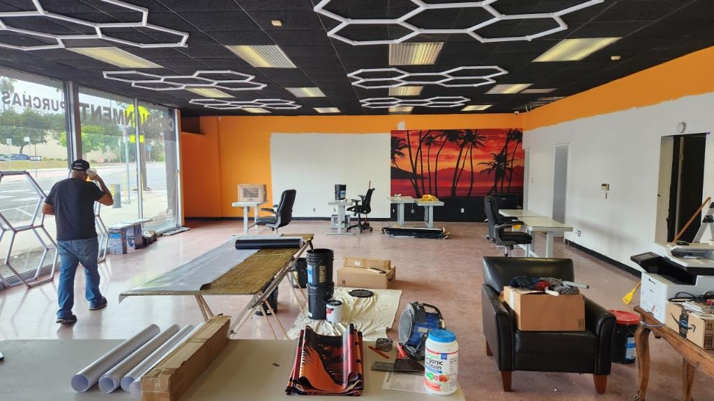 Commercial office space mid-installation with tropical sunset mural in progress